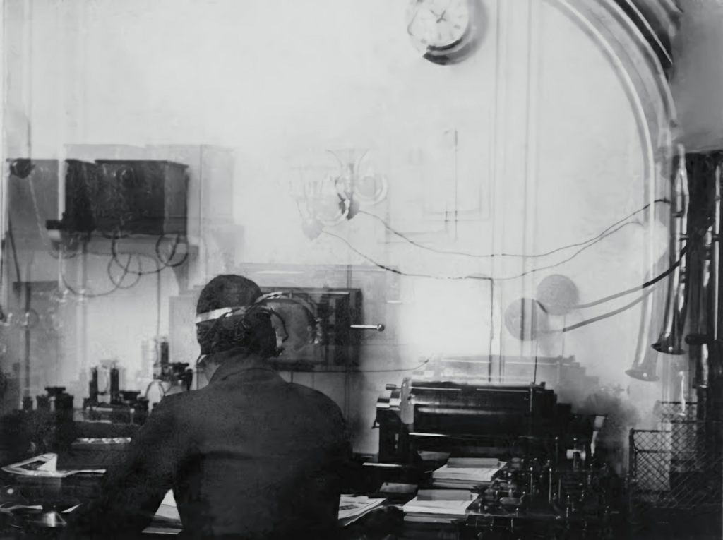 The only known picture of Titanic's wireless radio room, taken by the Catholic priest Francis Browne. Harold Bride is seated at the desk.
