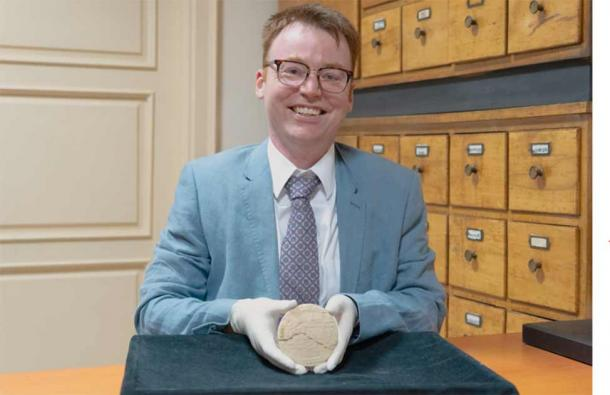 Dr. Mansfield, grasping the Babylonian clay tablet that provides proof of the use of Pythagorean Triples