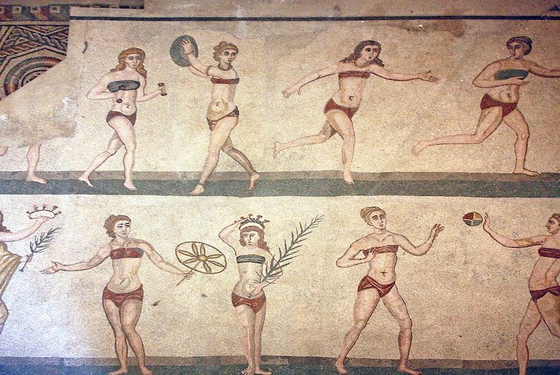 Roman women in a Sicilian mosaic from the 4th century AD exercising while wearing an amictorium, a bikini-type linen garment that covers their breasts.