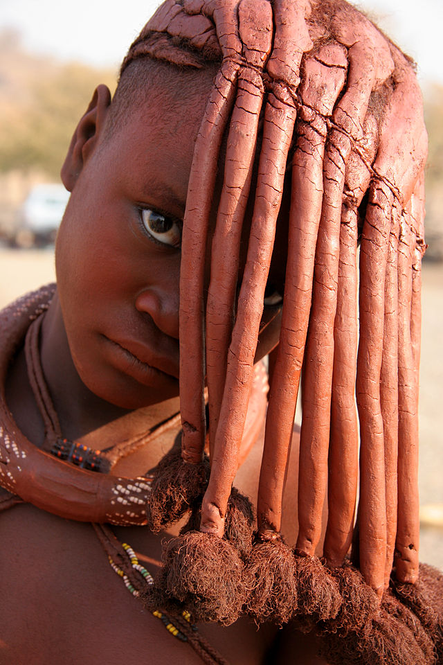 Himba people adorned in traditional attire, showcasing their unique cultural practices against the backdrop of Namibia's scenic landscapes.