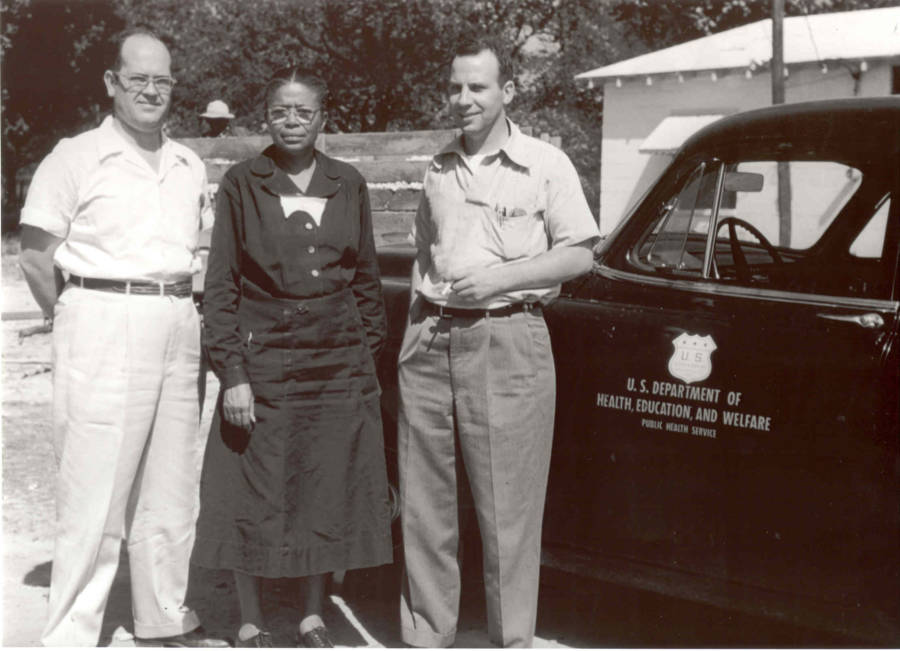 A photograph captures Eunice Rivers posing with two doctors who played a role in the Tuskegee experiment.

